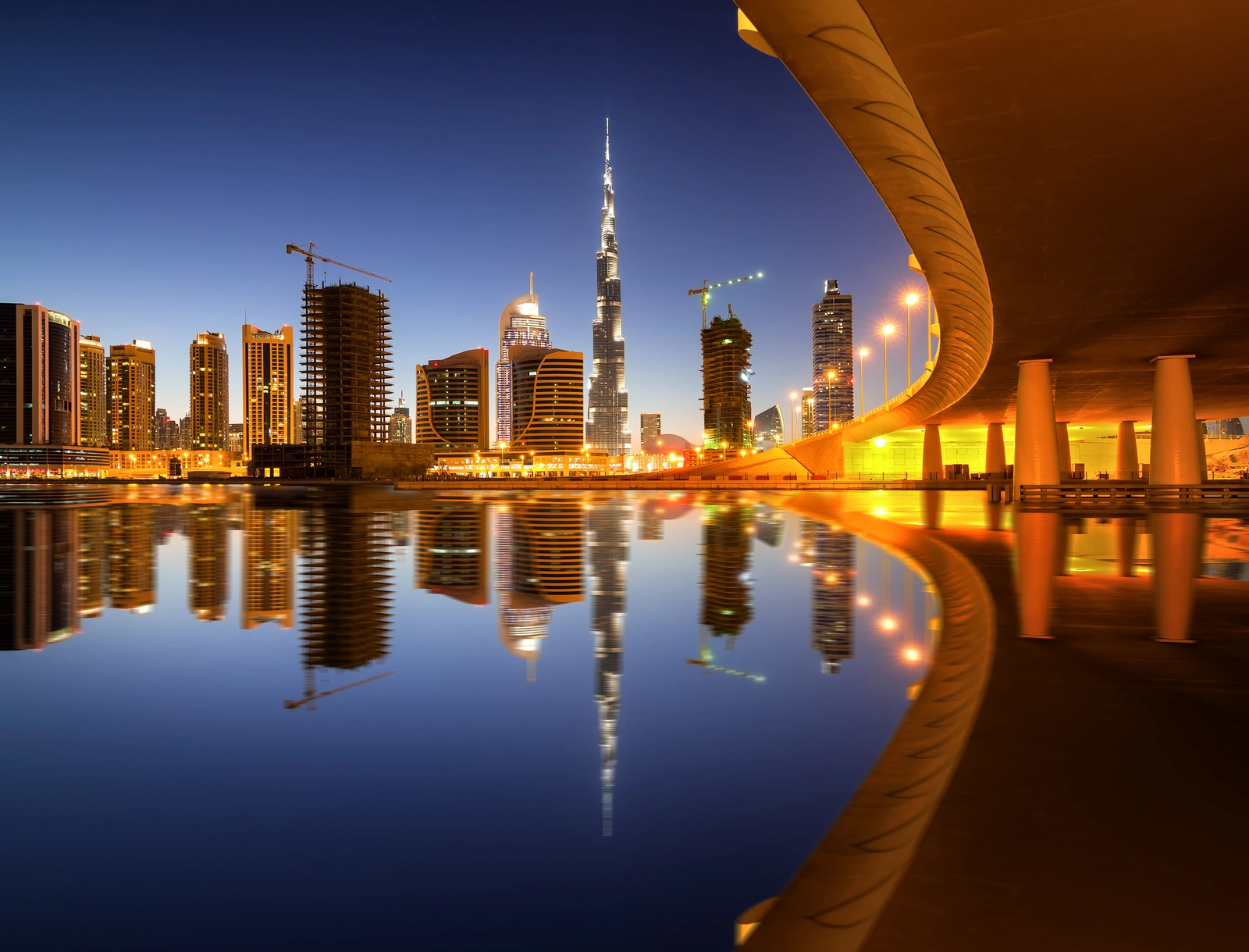 Dubai Business Bay skyscrapers reflected in water — Dubai business setup cost breakdown 2026