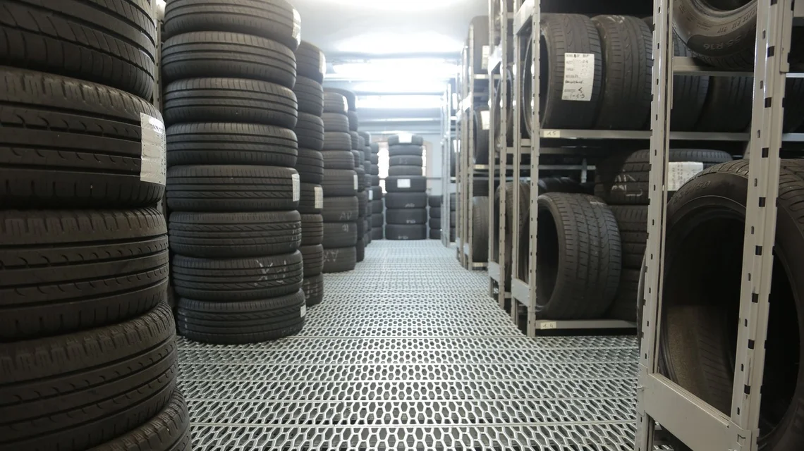 Rows of car tyres stored on racks in a tyre warehouse