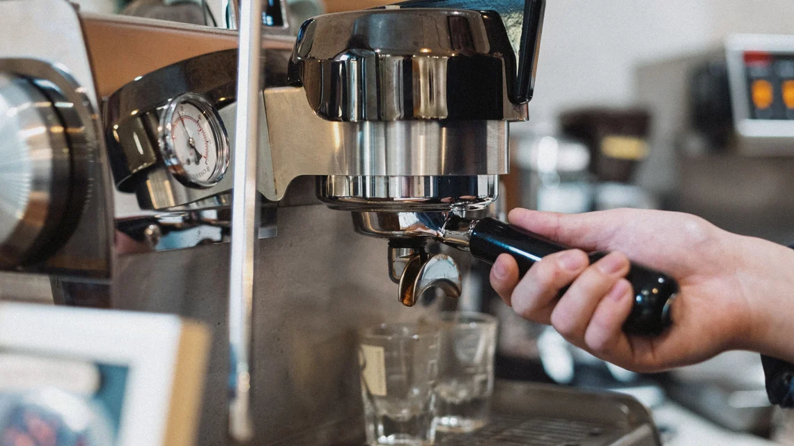 Barista preparing espresso behind the counter of a modern Dubai speciality coffee shop