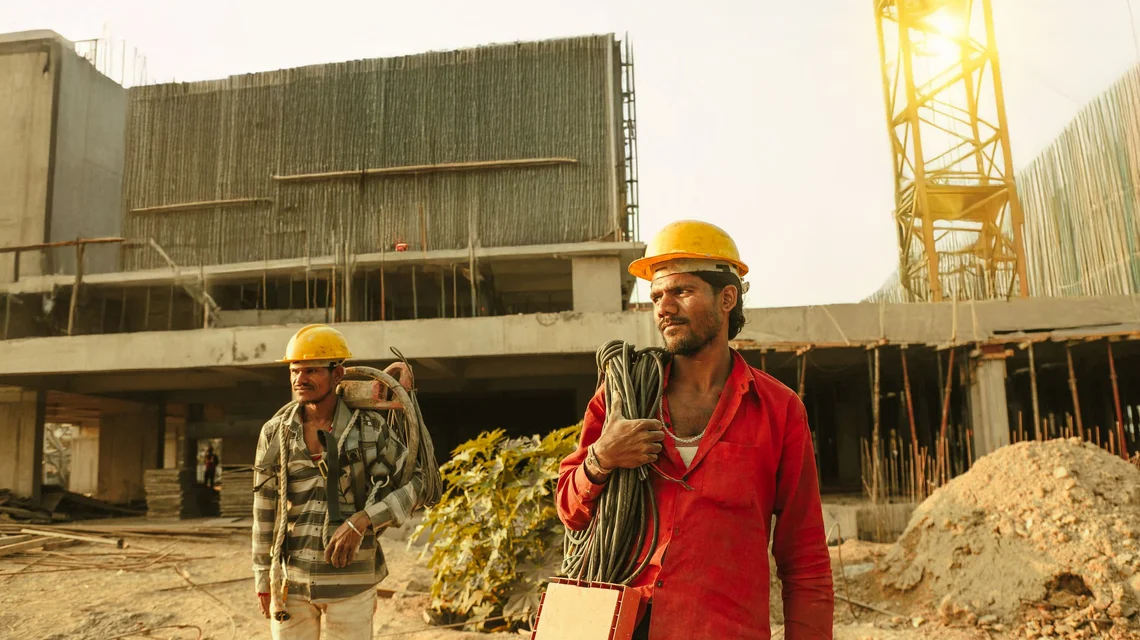 Construction workers carrying materials on a building site in the Gulf