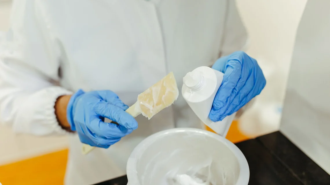 Technician in gloves blending cosmetic cream in a laboratory