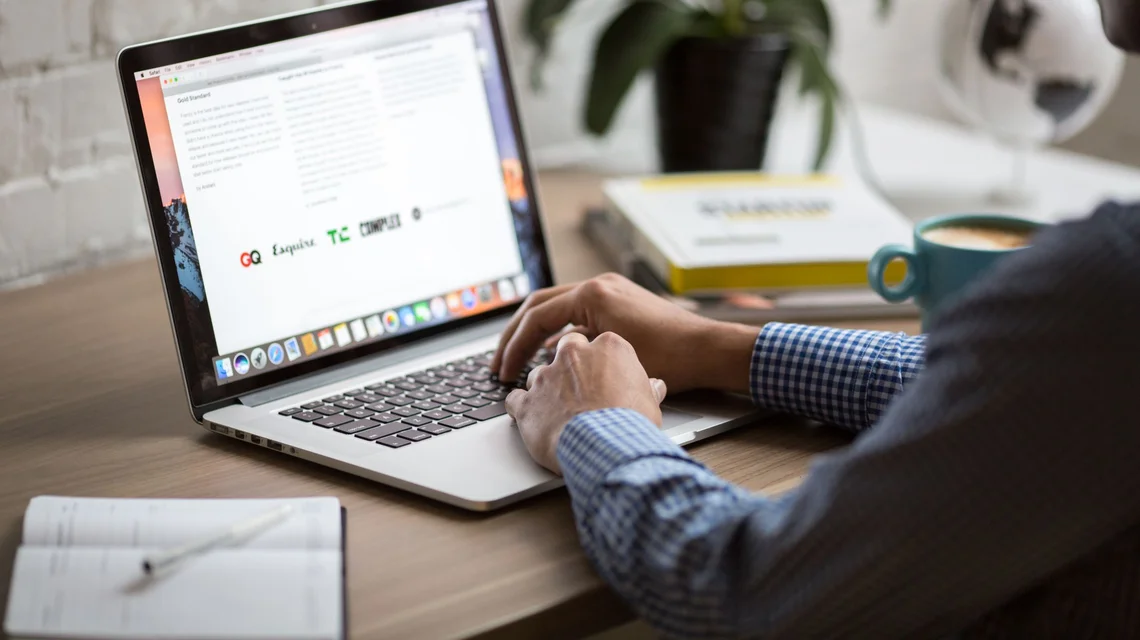 A media professional reviewing licence costs and tax figures on a laptop at a desk