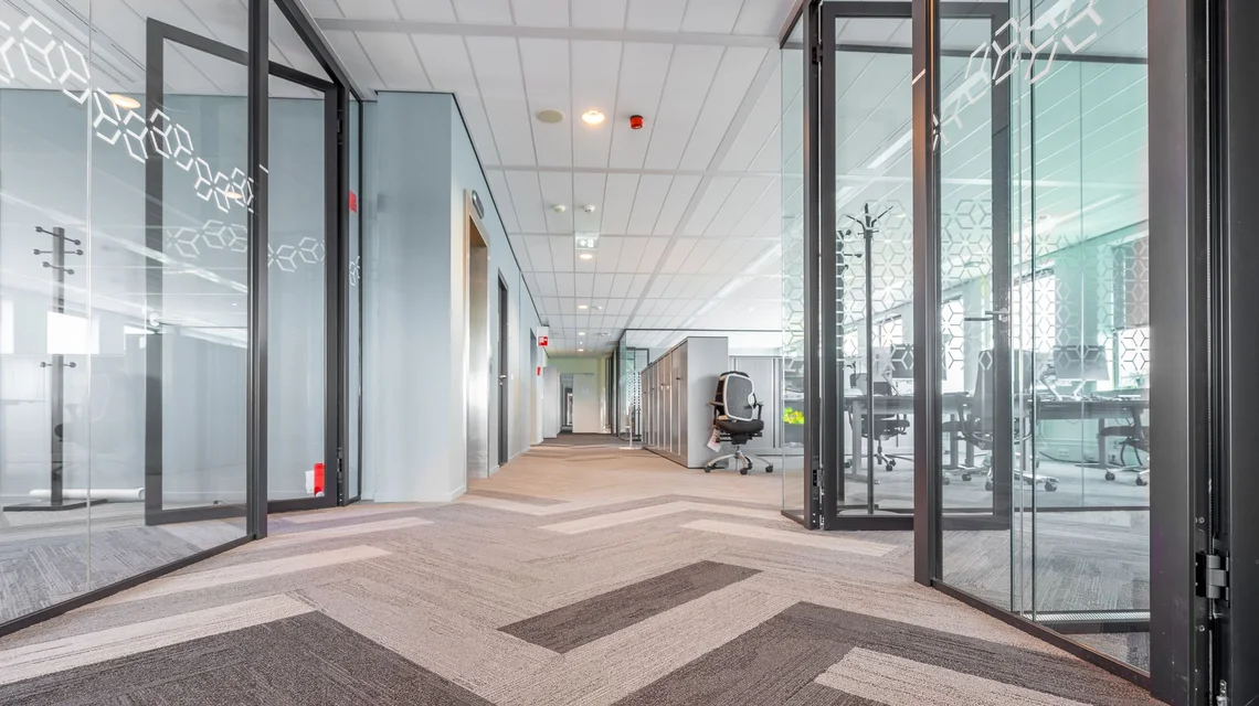 An empty fitted office unit with glazed partitions and open floor space, of the kind inspected before signing a commercial tenancy