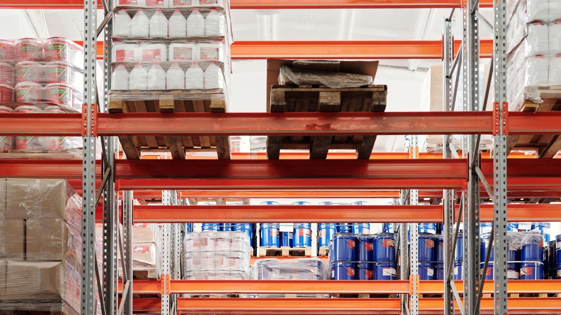 Interior of a warehouse unit with steel racking and a roller shutter door, the type of premises covered by a commercial tenancy contract