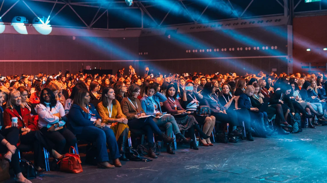 Audience at a produced corporate conference under stage lighting in Dubai