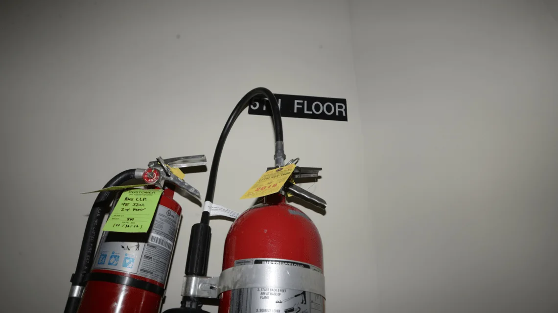 Red fire extinguishers positioned against a wall