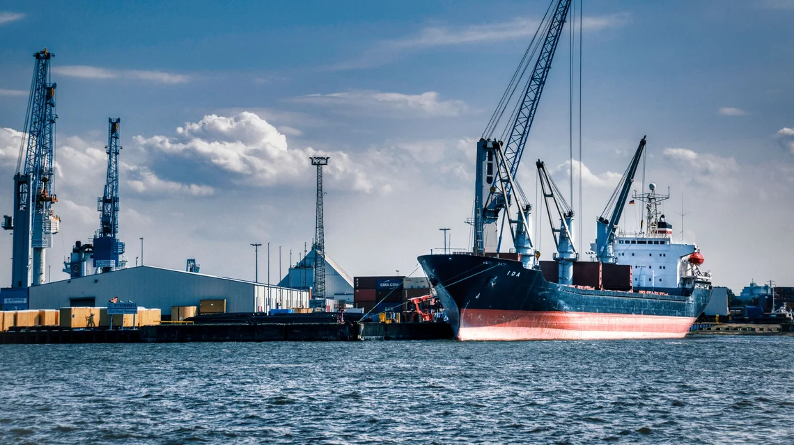 Container ship being loaded at a Dubai port terminal with gantry cranes overhead