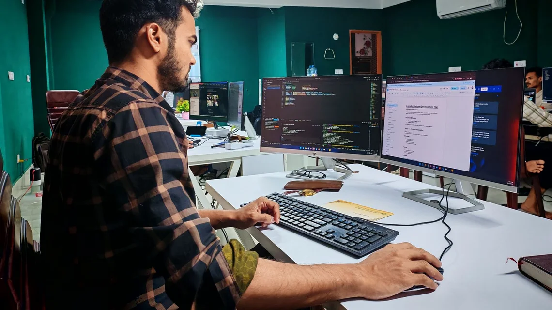 Game developer working on a video game at a multi-monitor workstation