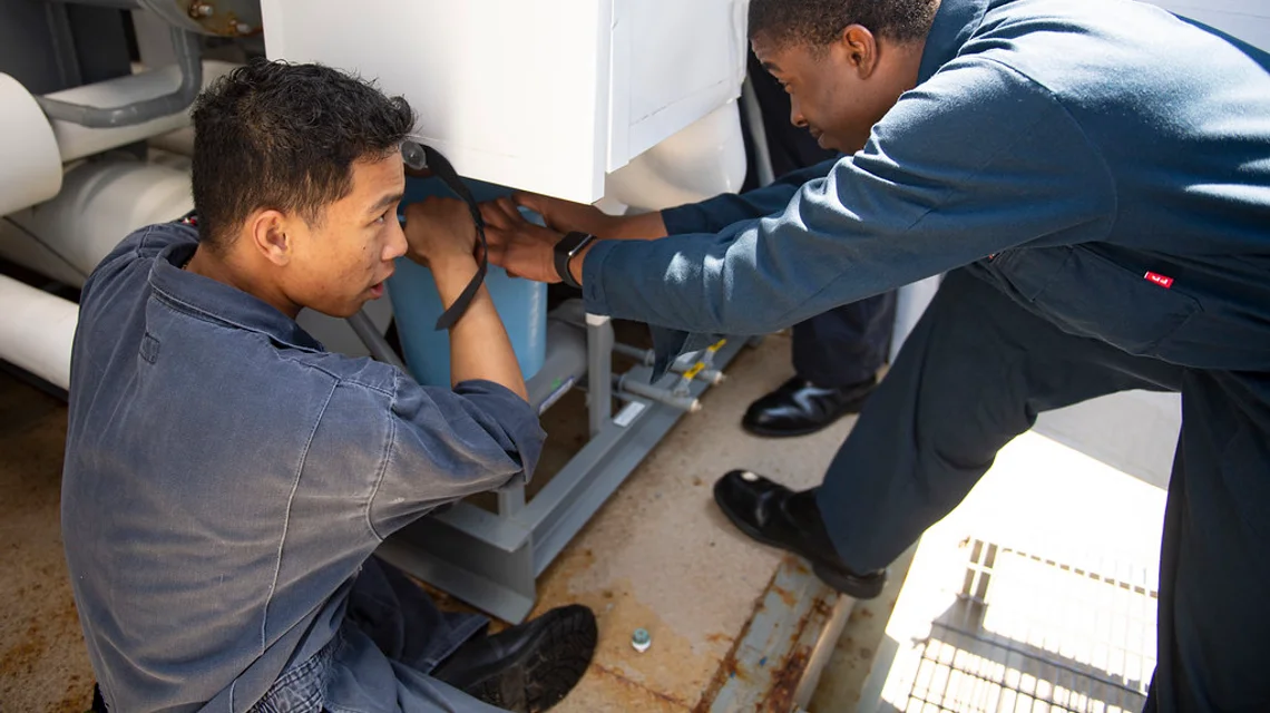 Technicians servicing an air conditioning unit
