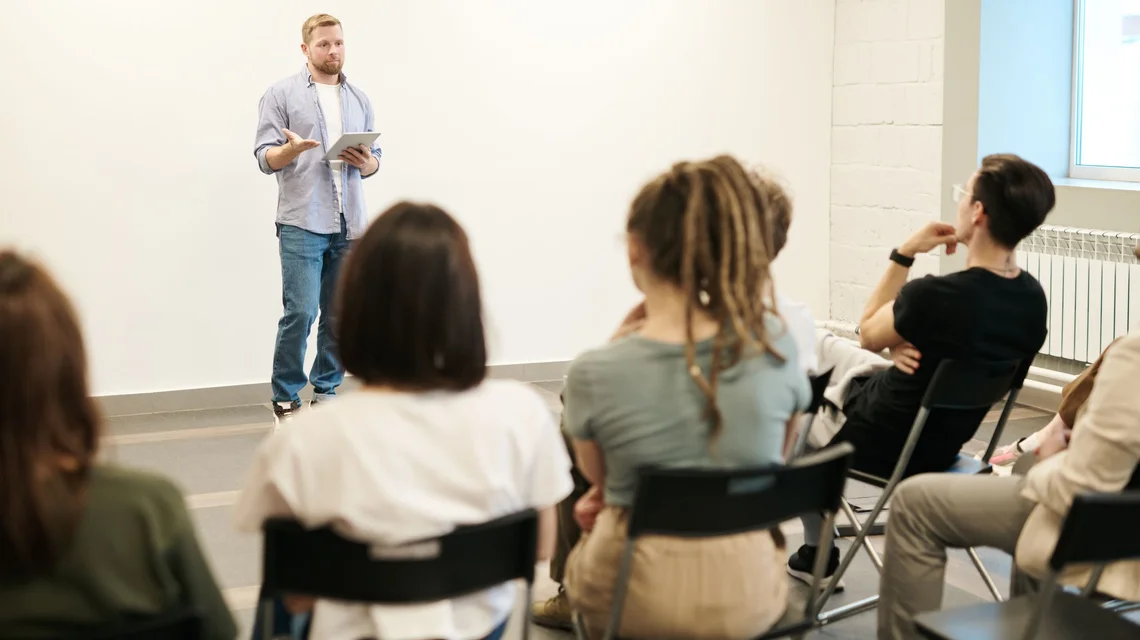 Adult learners in a Dubai training centre classroom with an instructor at a whiteboard