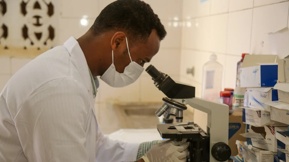 Laboratory technician examining a sample under a microscope