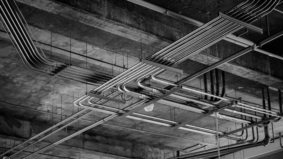 Mechanical plant room with chilled water pipework, pumps and electrical control panels