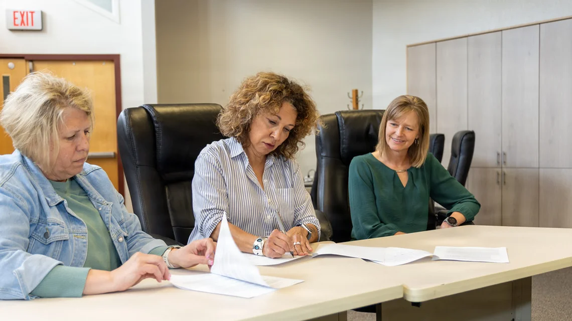 Mortgage adviser reviewing home-loan documents with clients
