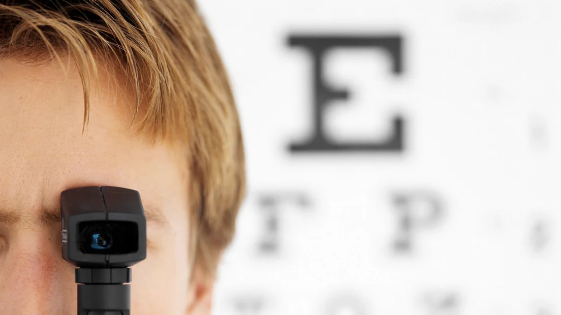 Optometrist performing an eye test on a patient with an examination device