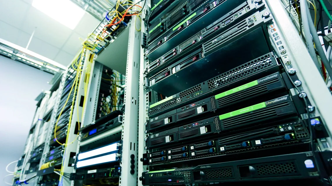 Rows of server racks with cabling in a data centre aisle