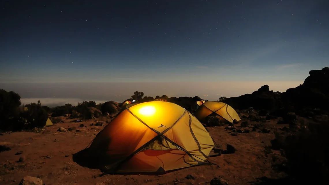 A lit tent at a desert safari camp at dusk