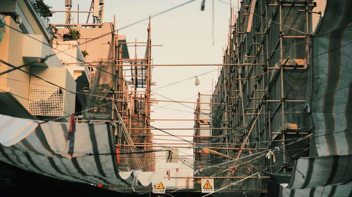 Scaffolders erecting tube and fitting access scaffold on the facade of a Dubai high-rise under construction