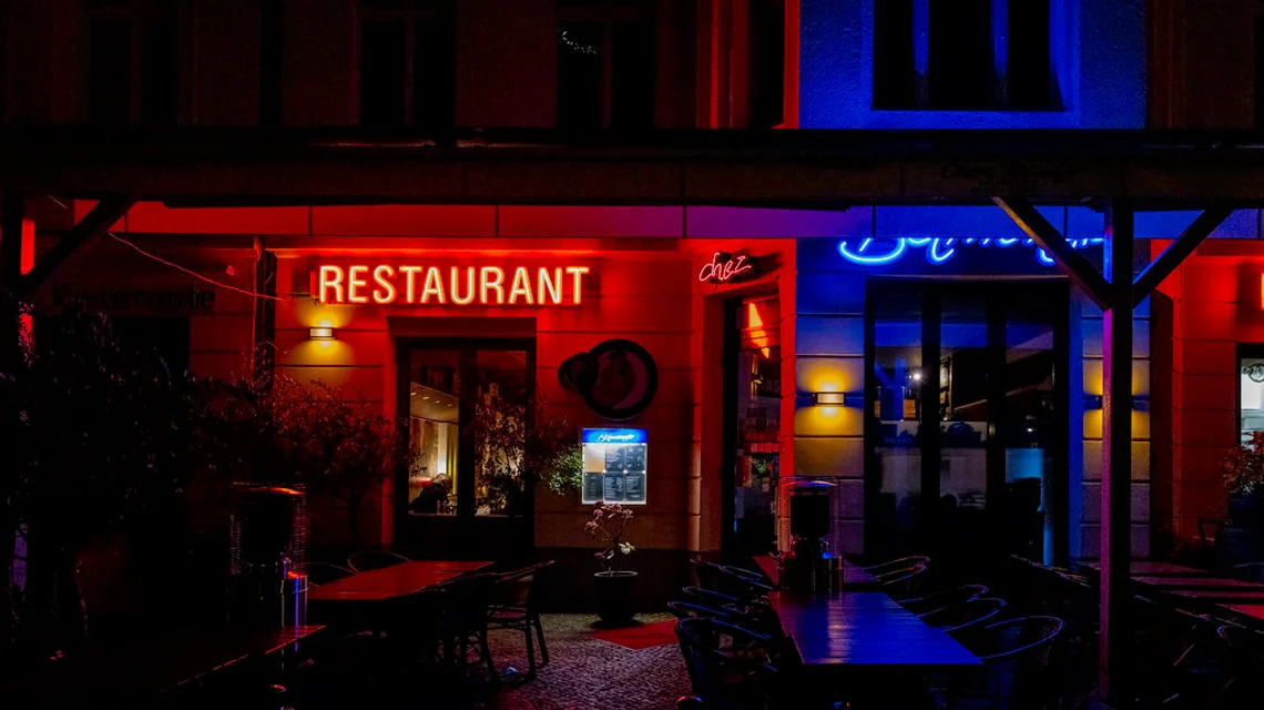 An illuminated shop sign glowing at night