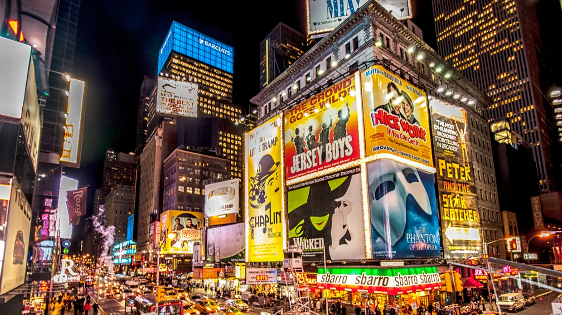 A cluster of digital LED advertising billboards lit up at night