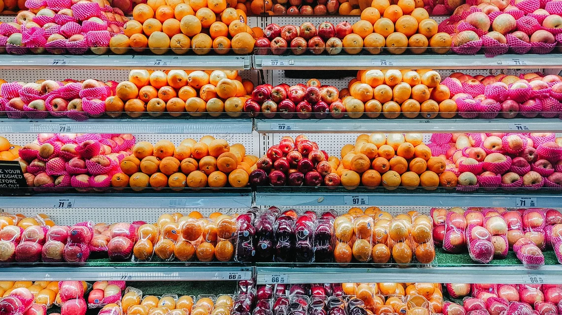 Fresh fruit displayed on refrigerated supermarket shelves