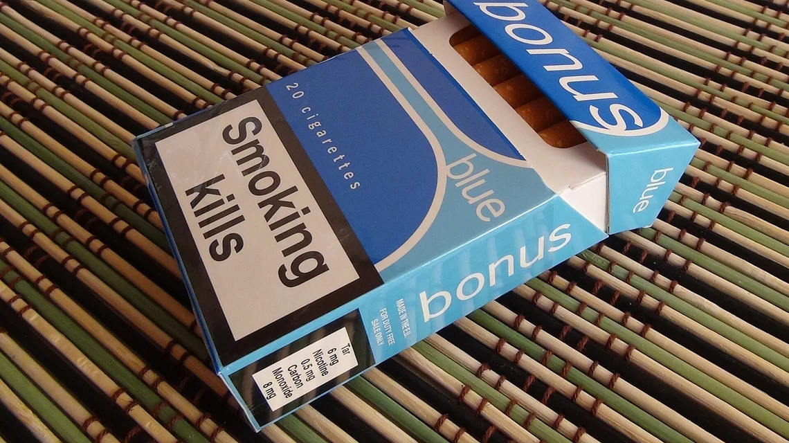 Cartons of cigarettes with health warning labels on a shelf