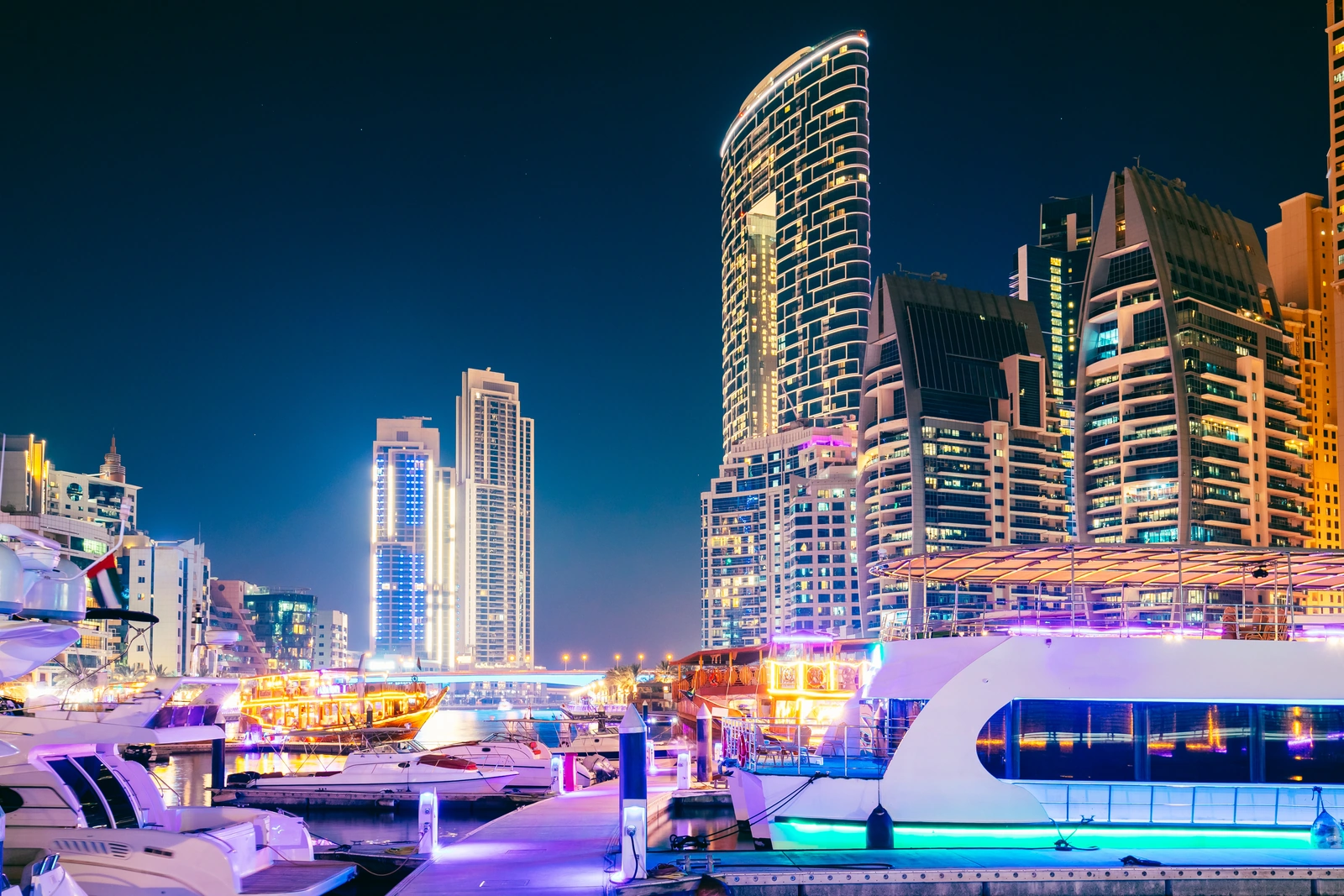 Yachts and boats moored at Dubai Marina at night — starting a yacht rental business in Dubai