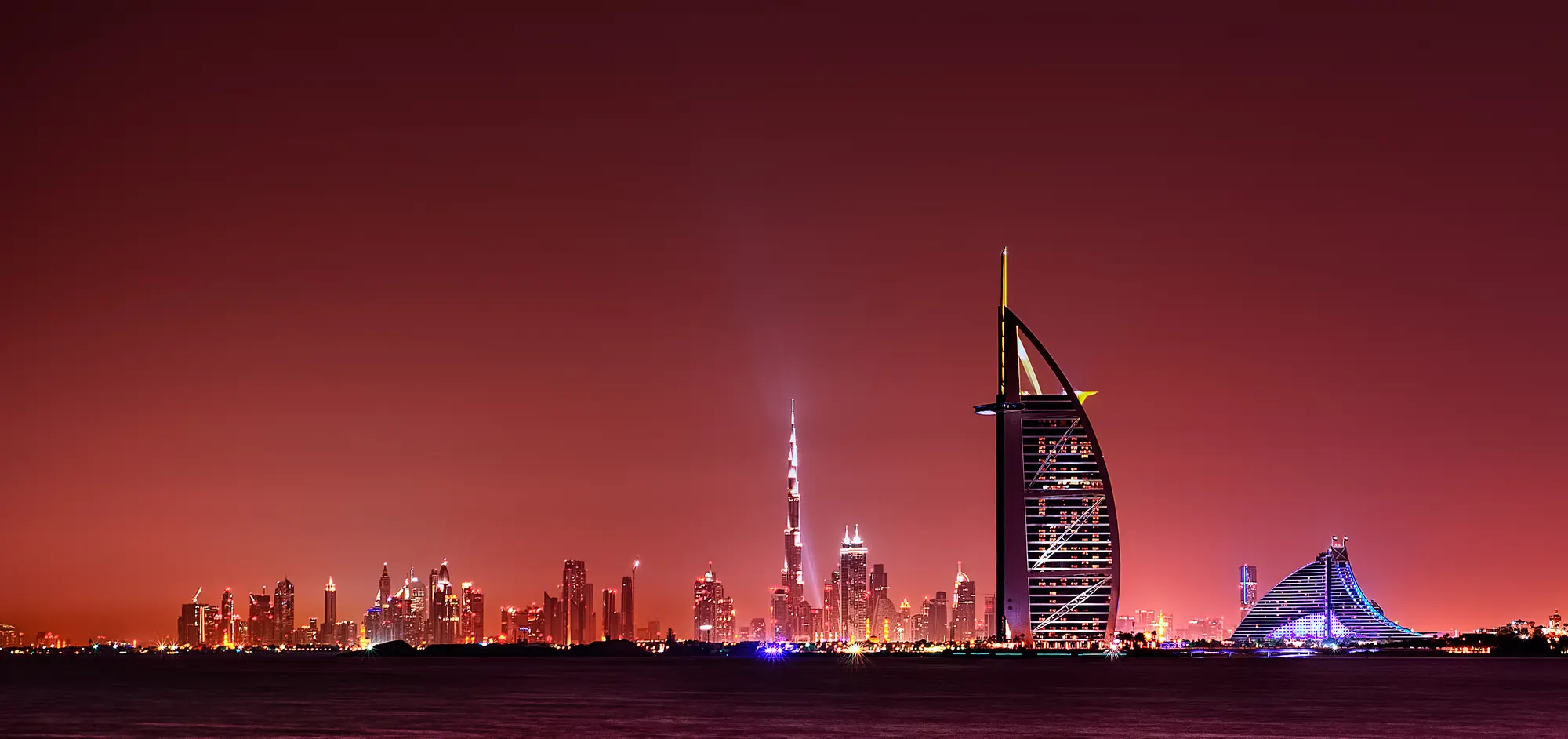Dubai skyline at night reflected over the water